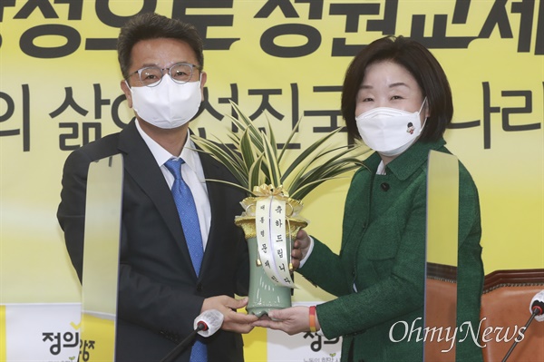 정의당 심상정 대선 후보(오른쪽)가 16일 오후 서울 여의도 국회에서 이철희 청와대 정무수석으로부터 문재인 대통령의 축하 난을 전달받고 있다.