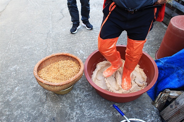 콩을 삶은 후  절구통 대신에 발로 밟는 모습