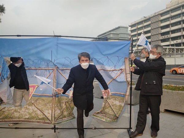  분단선 철조망을 찢고 나와 단일기를 흔드는 퍼포먼스를 하는 참가자들