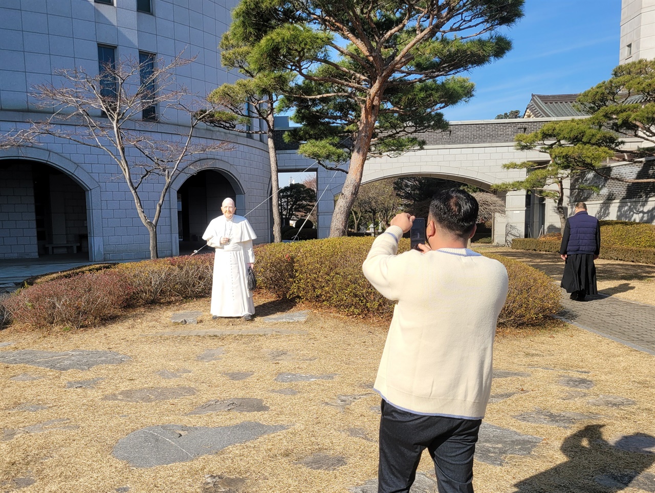 해미국제성지를 방문한 한 순례객이 프란치스코 교황 조형물을 카메라에 담고 있다.