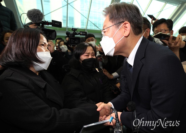 더불어민주당 이재명 대선후보(오른쪽)가 지난  8일 오후 국회 의원회관 3층 전시공간에서 고 김용균 3주기 추모 사진전을 살펴본 뒤 고인의 어머니 김미숙 김용균재단 이사장에게 인사하고 있다. 