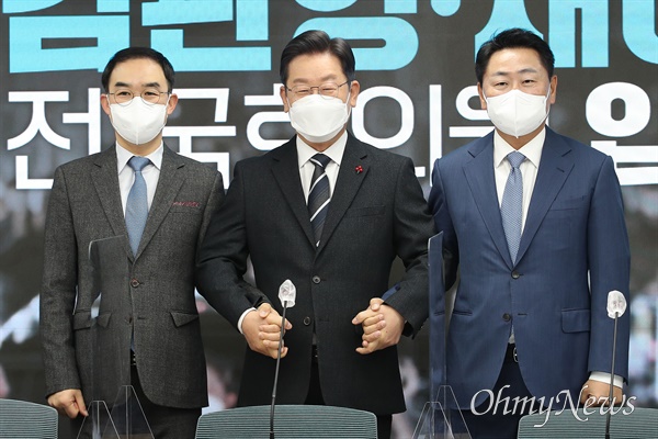 더불어민주당 이재명 대선 후보가 지난해 12월 10일 오전 서울 여의도 당사에서 열린 김관영·채이배 전 국회의원 입당식에서 두 전 의원의 손을 잡고 있다.
