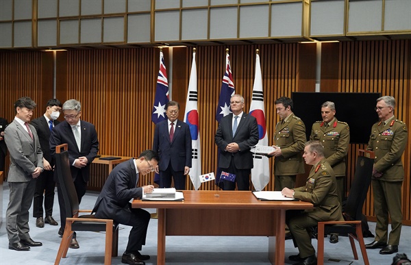 호주를 국빈 방문 중인 문재인 대통령이 지난해 12월 13일 캔버라 국회의사당에서 열린 한화 디펜스와 호주 국방부 획득관리단의 호주 육군 K-9 자주포 획득사업 계약 서명을 스콧 모리슨 총리와 함께 바라보고 있다.