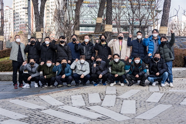 12월 16일, 합의가 이루어지고 서울 대성산업 본사 농성장을 정리한 후에 단체사진 촬영 중인 한국게이츠 19명의 노동자들