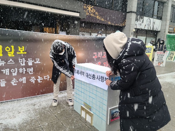 참가자들이 조선일보 모형에 '적폐세력 대선총사령부' 글씨를 붙이고 있다.