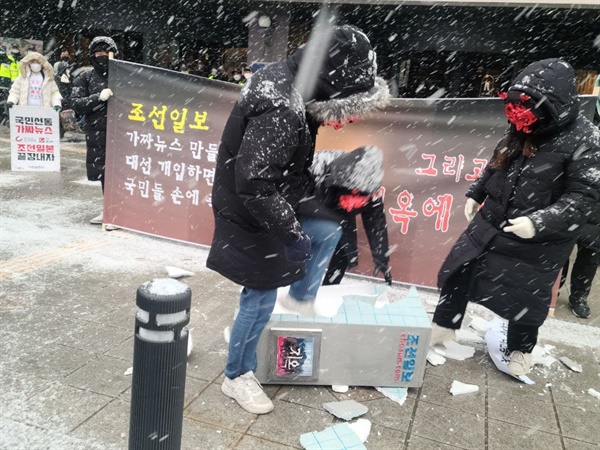 참가자들이 조선일보 모형을 부수고 있다.