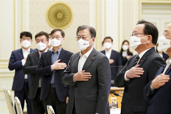  문재인 대통령이 20일 청와대 영빈관에서 열린 ‘2022년도 경제정책방향’ 보고 확대 국민경제자문회의에서 국민의례를 하고 있다.