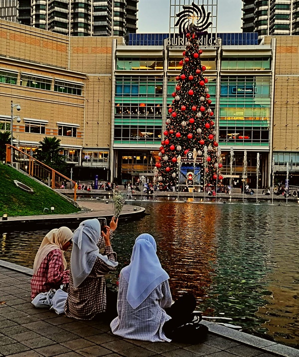 젊은 무슬림 여성들이 대표적 관광지인 쌍둥이빌딩 앞에 5층 높이로 설치된 대형트리의 점등을 기다리고 있다.