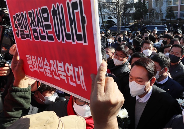 국민의힘 윤석열 대선 후보가 22일 오후 전북 전주시 덕진구 전북대학교 이세종 열사 추모비 앞에서 헌화하려다 이를 반대하는 시민단체의 항의를 받고 있다. 윤 후보는 결국 추모비 대신 이세종 열사 표지석에 헌화했다.