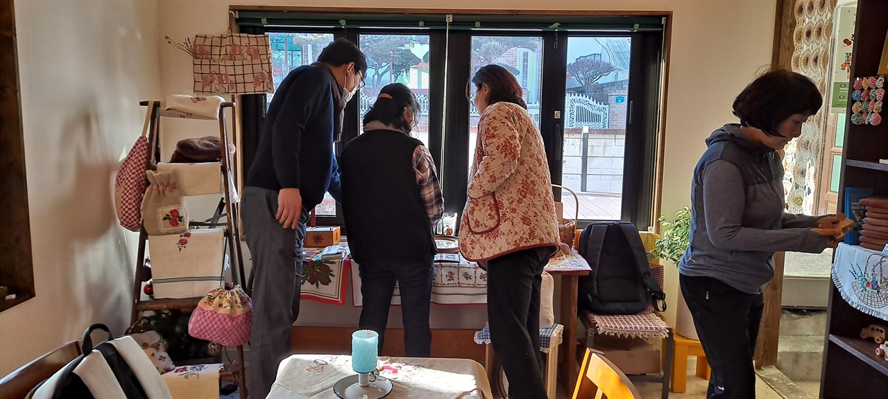  시민들이 프랑스 자수와 조각작품을 구경하고 있다. 