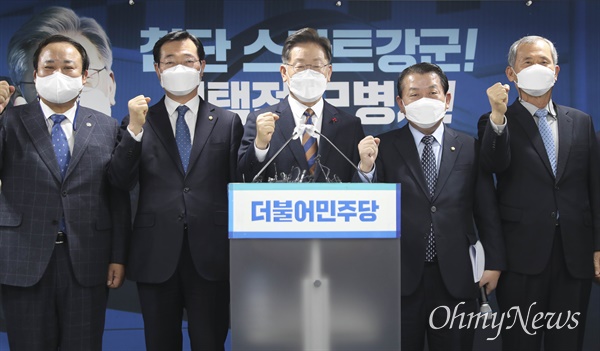 더불어민주당 이재명 대선 후보가 2021년 12월 24일 서울 여의도 중앙당사에서 '스마트강군, 선택적 모병제' 공약 발표를 마친 후 참석자들과 함께 기념촬영을 하고 있다.