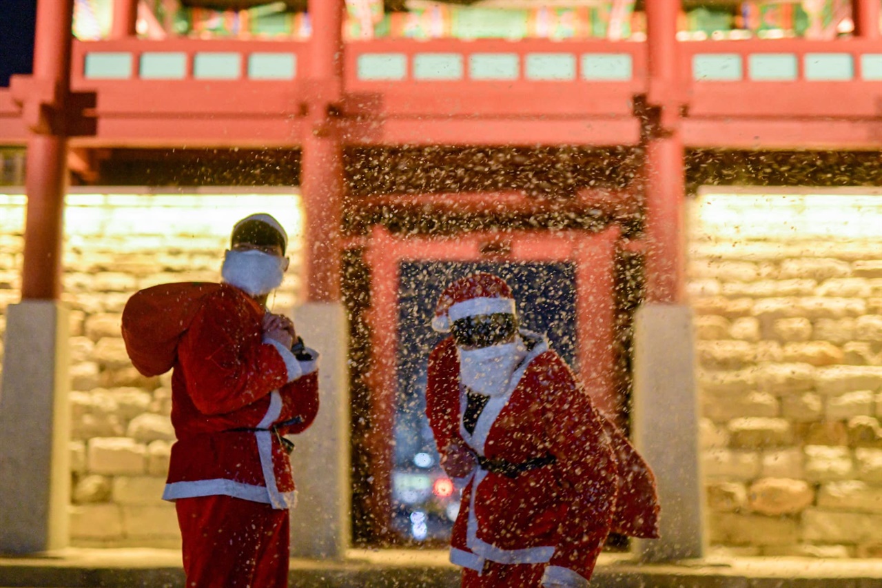 한국영화인총연합회 홍성지부장도 맡고 있는 노 감독(사진 오른쪽)은 성탄절인 지난 25일 산타로 분장하고, 시민들과 거리에서 고생하는 교통 경찰 등에게 선물을 나누어 줬다. 