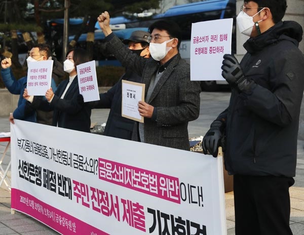 지난 23일 오후 서울 영등포구 금융감독원 앞에서 '신한은행 폐점에 따른 피해 해결을 위한 주민대책위원회' 관계자들이 노원구 월계동지점 통폐합 방침에 반발하는 기자회견을 열고 구호를 외치고 있다.