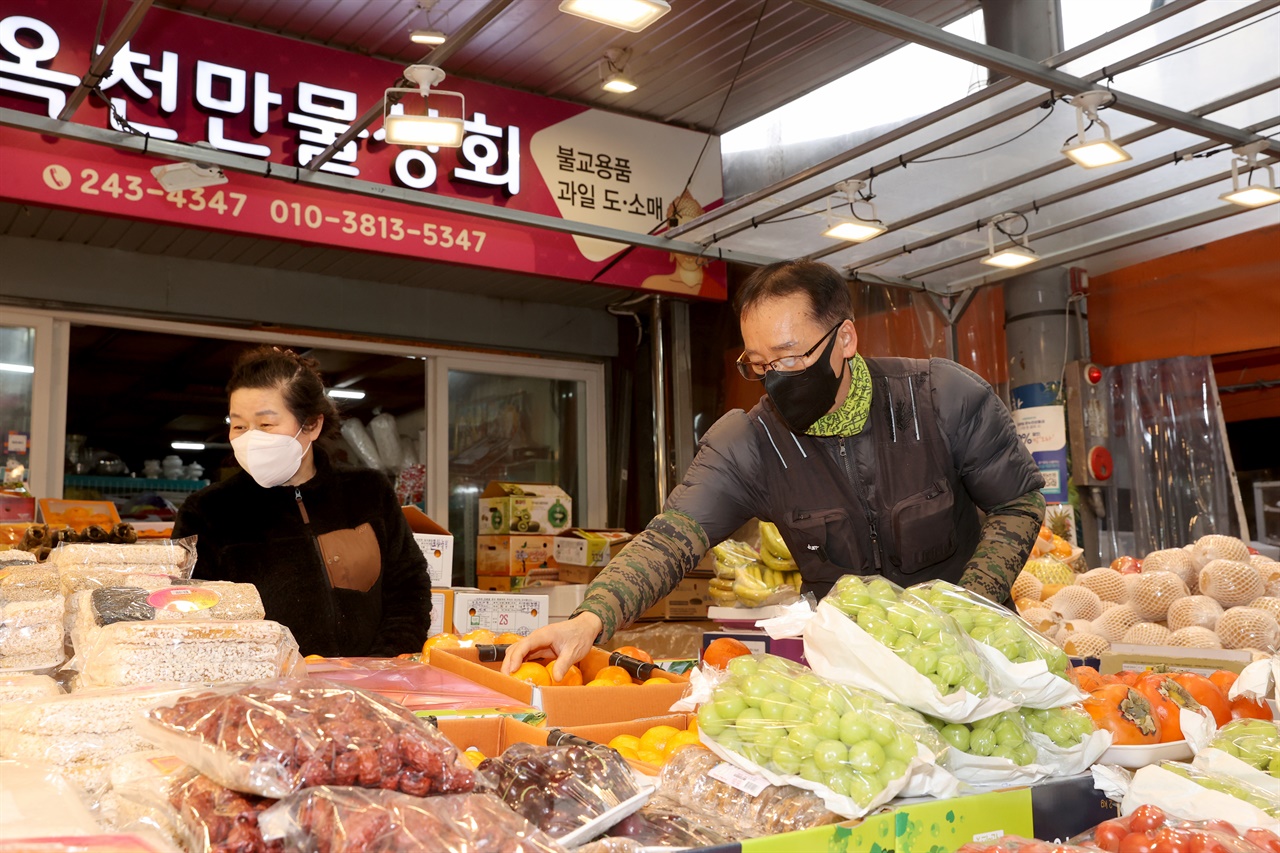 진열된 과일을 정리하고 있는 죽도시장 박두인-이방숙 부부.