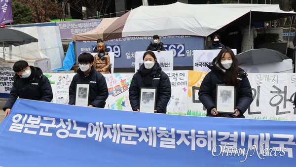 소녀상 지킴이로 알려진 반일행동 소속 청년들이 5일 오후 서울 종로구 옛 주한일본대사관 앞 소녀상 앞에서 위안부 피해자들의 사진을 들어보이며 일본의 전쟁 성범죄에 대한 공식 사죄와 법적 배상을 촉구하고 있다.