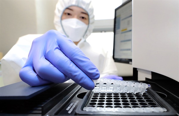 2021년 12월 30일 세종시 조치원읍 세종보건환경연구원에서 보건연구사가 코로나19 오미크론 변이 신속 분석을 위해 검체를 실시간 PCR증폭 장비에 넣고 있다. 