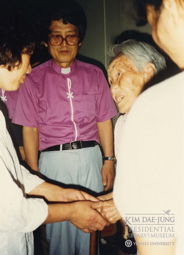 이 사진은 1987년 7월 이한열 열사의 빈소에서 배은심 여사를 위로하는 김신묵 권사의 모습이다. 사진 가운데는 문동환 목사이다. 