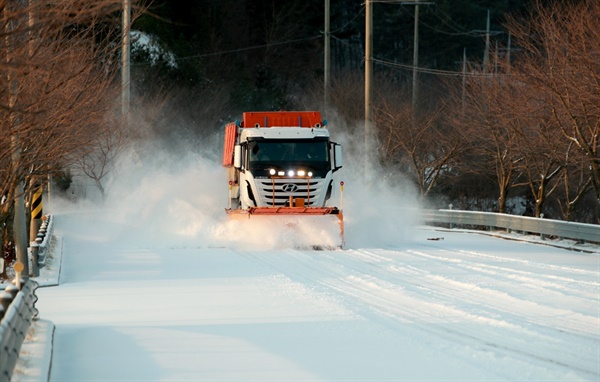 13일 오전 충남 지역에 눈이 내린 가운데, 한 제설차가 태안 도로에 쌓인 눈을 치우고 있다.