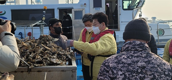  더불어민주당 김정호 경남도당 위원장과 백두현 고성군수가 굴 양식장을 찾아 살펴보고 있다.