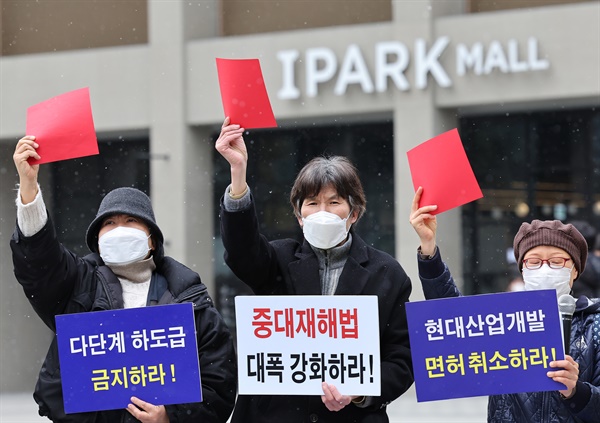 안전사회시민연대 관계자들이 17일 오후 서울 용산구 현대산업개발 본사 앞에서 광주 아파트 붕괴 참사를 규탄하는 기자회견을 하던 중 레드카드를 들어보이는 퍼포먼스를 하고 있다.