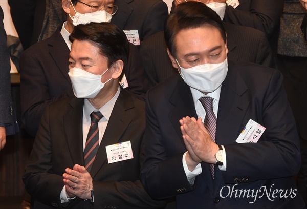  국민의힘 윤석열 대선 후보와 국민의당 안철수 대선 후보가 지난 17일 오후 서울 중구 신라호텔에서 열린 불교리더스포럼 제5기 출범식에서 기념 촬영을 한 뒤 합장하고 있다.