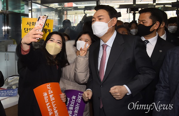 국민의힘 윤석열 대선 후보가 1월 18일 서울 영등포구 사회복지사협회에서 열린 간담회에 참석하며 관계자의 셀카 촬영에 응하고 있다.