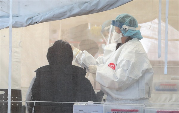 부산에서 오미크론 변이 바이러스의 지역 감염이 확산세를 보인 13일 오후 사상구보건소 선별진료소를 찾은 시민들이 신종 코로나바이러스 감염증(코로나19) 검사를 받고 있다. 