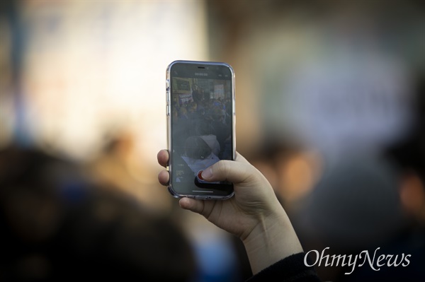 21일 서울 마포구 연남동 거리에서 '걸어서 민심 속으로' 연남동 거리 걷기 행사에서 나선 더불어민주당 이재명 대선 후보를 한 시민이 스마트폰으로 촬영하고 있다.