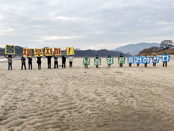  낙동강 모래톱 걷기 참여자들이 현수막 퍼포먼스를 벌이고 있다. 