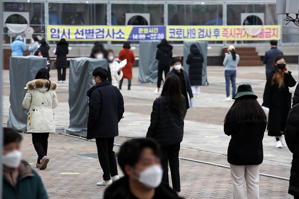 24일 오후 광주시청 광장에 마련된 임시선별검사소에서 코로나19 검사를 받으려는 시민들이 길게 줄 서 있다.