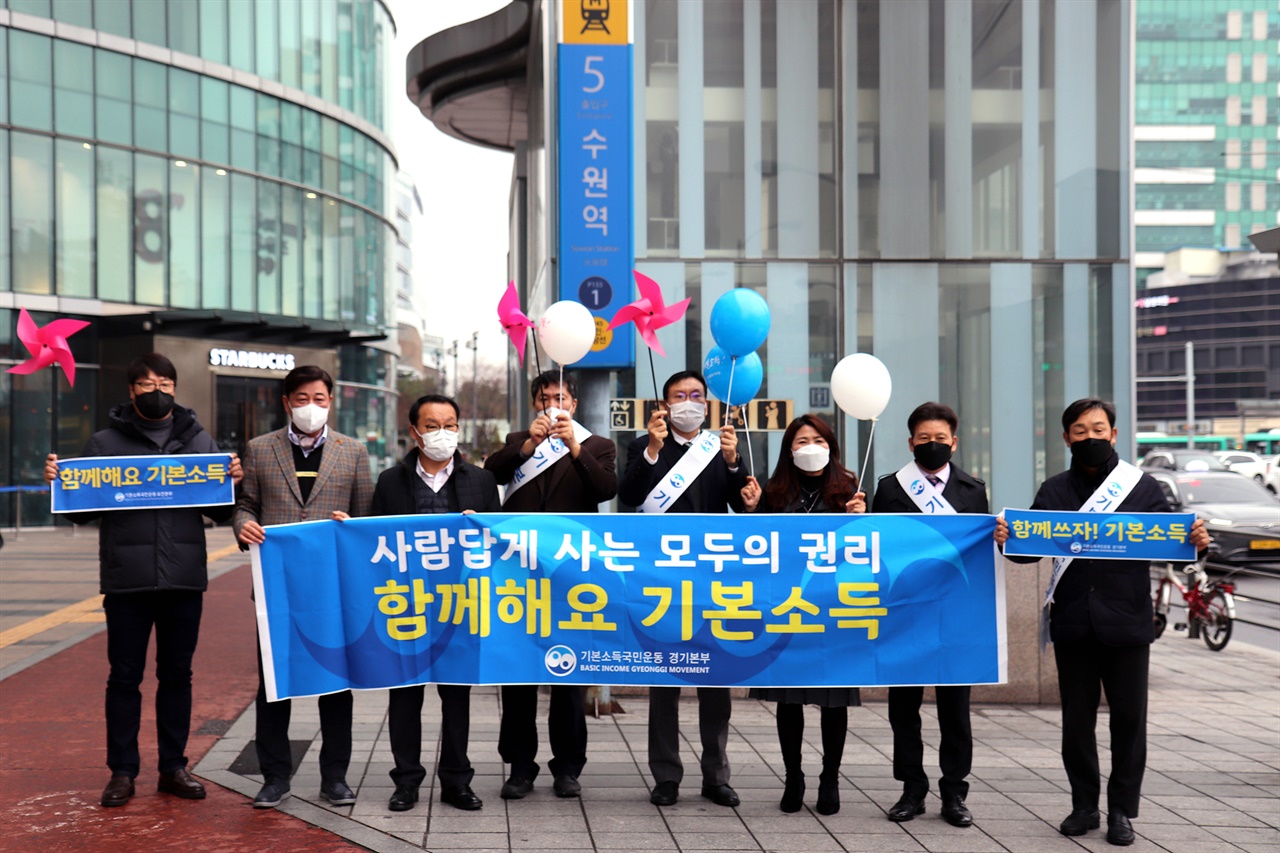  수원역에서 기본소득 홍보캠페인을 진행하고 있는 기본소득국민운동 경기본부 회원들