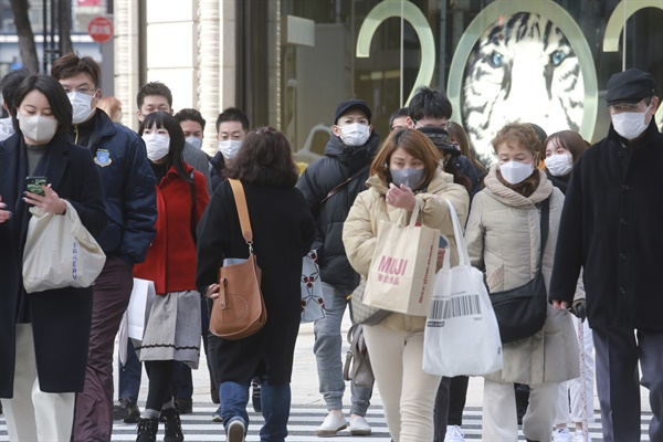  지난 1월 25일 일본 도쿄도에서 마스크를 쓴 사람들이 횡단보도를 건너고 있다. 일본의 코로나19 신규 확진자는 이날 처음으로 6만명을 넘었다.