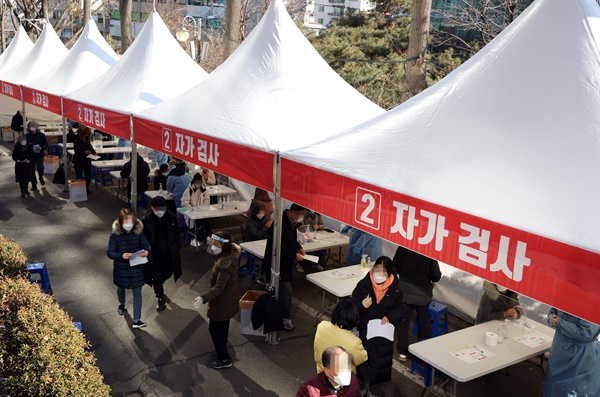 오미크론 확산에 대응하기 위한 코로나19 검사·진료체계가 전면 전환된 3일 오전 서울 광진구보건소 선별진료소에 마련된 신속항원검사소에서 시민들이 자가진단키트를 이용해 검사를 하고 있다.