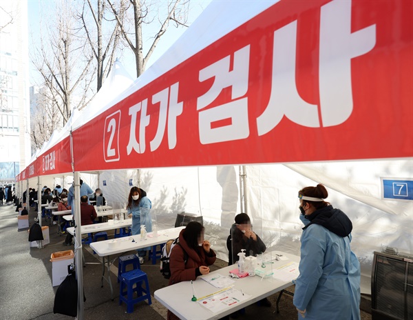 오미크론 확산에 대응하기 위한 코로나19 검사·진료체계가 전면 전환된 지난 3일 오전 서울 광진구보건소 선별진료소에 마련된 신속항원검사소에서 시민들이 자가진단키트를 이용해 검사를 하고 있다.