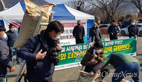 농민단체들이 15일 오전 경남도청 정문 앞에서 '시장 격리용 쌀 입찰'에 대해 반대하며 기자회견을 연 뒤, 쌀 5포대를 더불어민주당 경남도당에 전달했다.