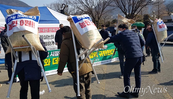  농민단체들이 15일 오전 경남도청 정문 앞에서 '시장 격리용 쌀 입찰'에 대해 반대하며 기자회견을 연 뒤, 쌀 5포대를 더불어민주당 경남도당에 전달했다.