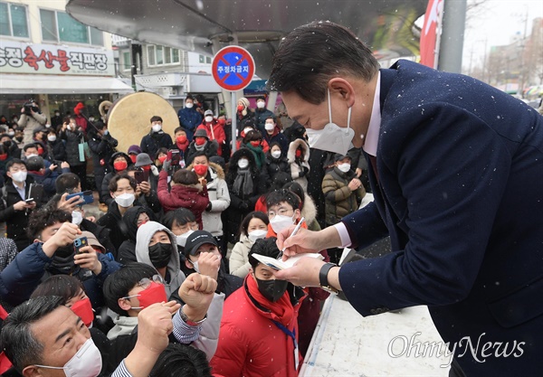 국민의힘 윤석열 대선 후보가 16일 오전 광주 송정매일시장에서 지지자들에게 사인을 하고 있다.