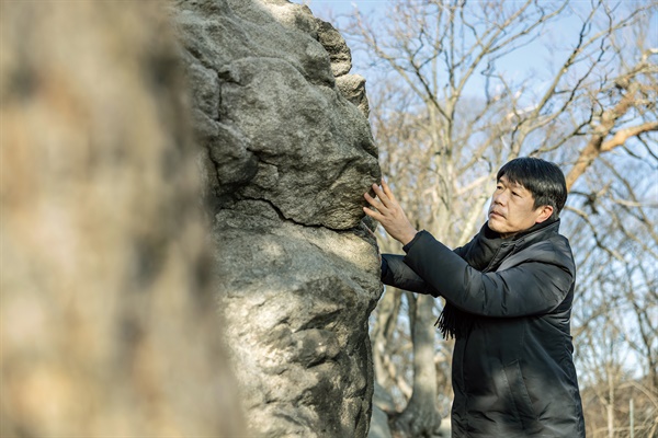  배성수 인천시립박물관 학예연구관이 인화리 호랑이바위를 살펴보고 있다.