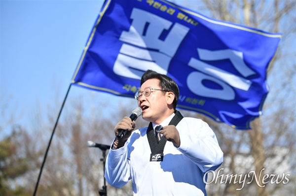 이재명 더불어민주당 대선후보가 20일 오전 경기도 수원시 장안구 만석공원에서 열린 유세에서 태권도복을 입고 '코로나 위기' '자영업자 고통'이 적힌 송판 격파 퍼포먼스를 벌인 뒤 지지를 호소하고 있다.