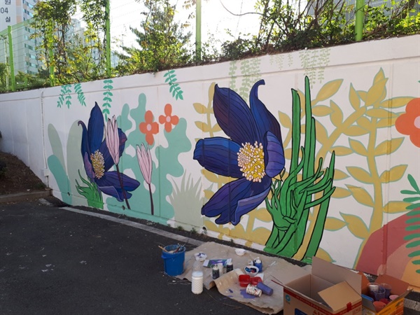 다사리학교의 미술반이 지역사회 어두운 담을 찾아 도시재생으로 꽃을 그렸다