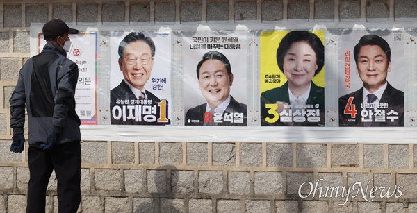 제20대 대통령 선거(3월9일)을 앞두고 19일 오후 김해 김수로왕릉 광장에서 한 시민이 대선 후보의 선거 벽보를 살펴보고 있다.