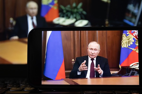 지난 21일(현지시각) 한 시민이 푸틴 러시아 대통령의 대국민연설 영상을 보고 있다. 