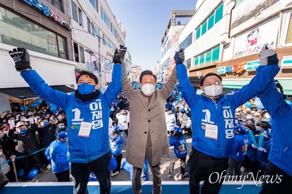  이재명 더불어민주당 대선후보가 24일 오후 강원도 원주 중앙로 문화의거리에 이광재(왼쪽), 허영 의원과 함께 손을 들어 올리고 있다.