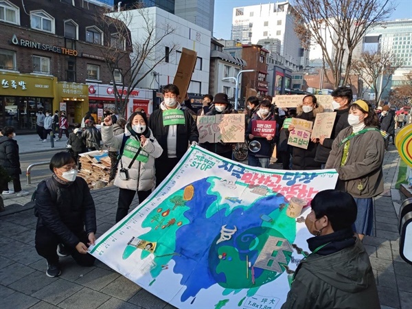 <동서울 시민의 힘 기후정의행동단> 회원들이 기후위기 STOP을 주제로 한 박스 재활용 피켓과 그림을 펼쳐들고 행진했다. 