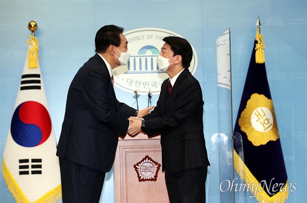  국민의힘 윤석열 대선 후보와 국민의당 안철수 대선 후보가 3일 오전 국회 소통관에서 단일화 기자회견을 마치고 악수하고 있다. 
