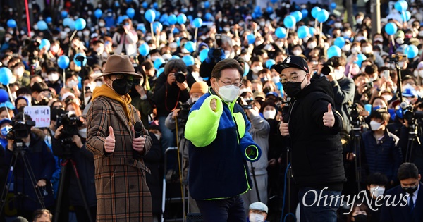 더불어민주당 이재명 대선 후보가 6일 서울 서대문구 신촌 유플렉스 앞 광장에서 열린 유세에서 후리스를 입고 래퍼들과 함께 인사하고 있다. 
