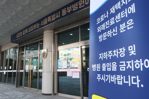  2월 9일 서울시립 동부병원에서 코로나19 재택치료 외래진료센터 안내문이 출입구 앞에 놓여 있다.