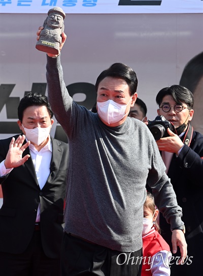 윤석열 국민의힘 대선 후보가 제20대 대통령선거 하루 전인 8일 제주시 일도1동에서 열린 유세에서 지지를 호소하며 어린이로부터 전달받은 하르방을 들어보이고 있다.