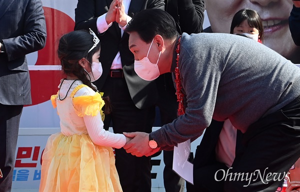  윤석열 국민의힘 대선 후보가 제20대 대통령선거 하루 전인 8일 제주시 일도1동에서 열린 유세에서 그림을 전달한 어린이와 대화하고 있다.