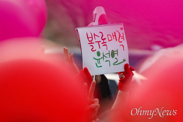 윤석열 국민의힘 대선후보가 8일 오후 대전 유성구 노은역 앞에서 열린 유세에서 지지를 호소하는 가운데 한 지지자가 '볼수록 매력 윤석열'이라고 적힌 공책을 들고 있다.
